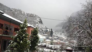 A snow-covered village with buildings, a mountain backdrop, and a clear sky.