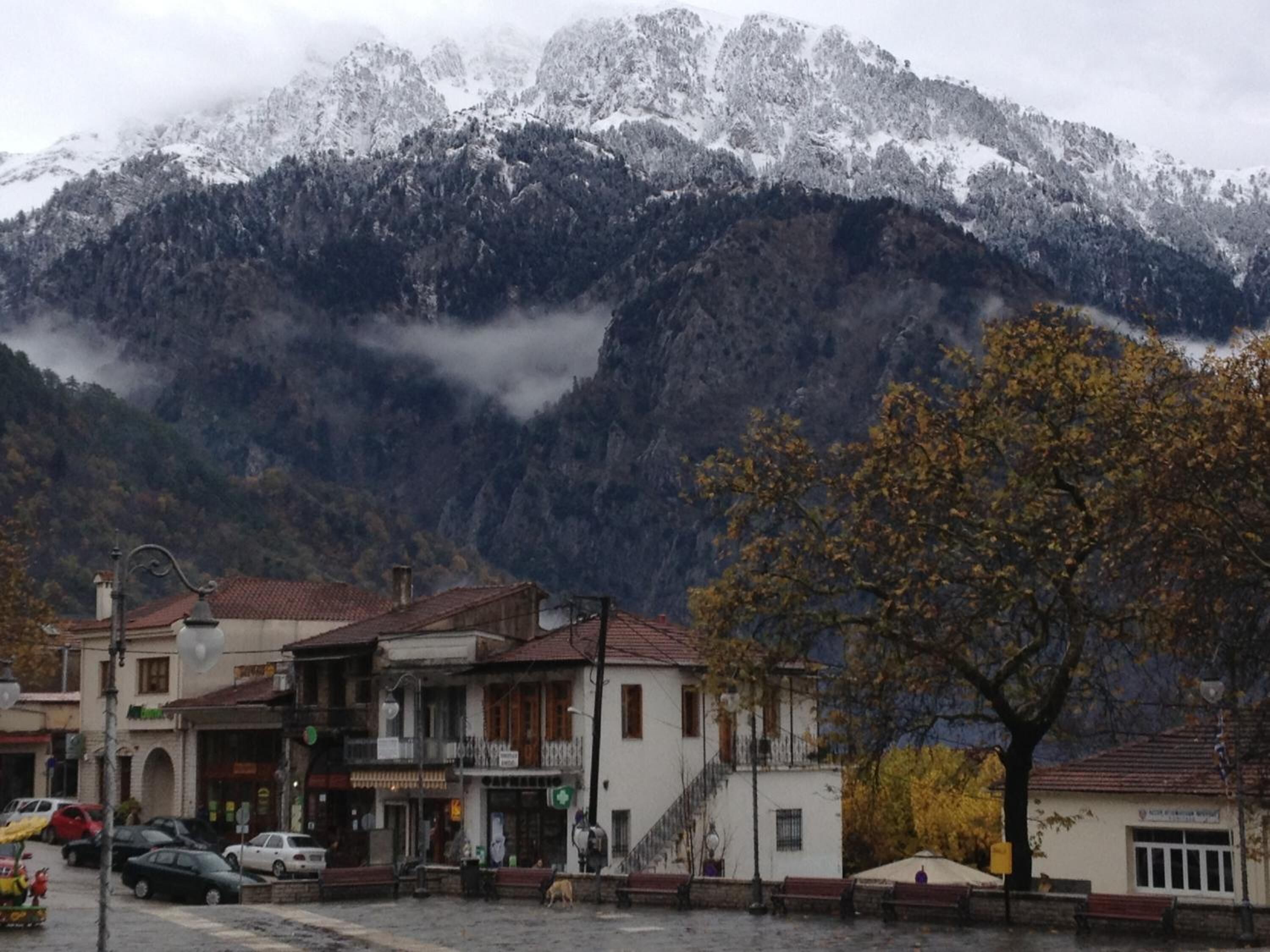 Eine Stadt mit Gebäuden im Vordergrund und einem Gebirge im Hintergrund.