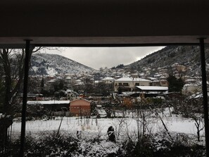 A snowy village with houses and a hill in the background.