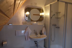 A bathroom with a sink, mirror, and shower. - Landhaus Foresta (Braunlage)