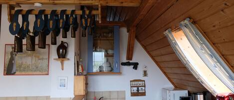 Eine Küche mit Holzausstattung, einem Spülbecken und verschiedenen Küchenutensilien, die an der Wand hängen.