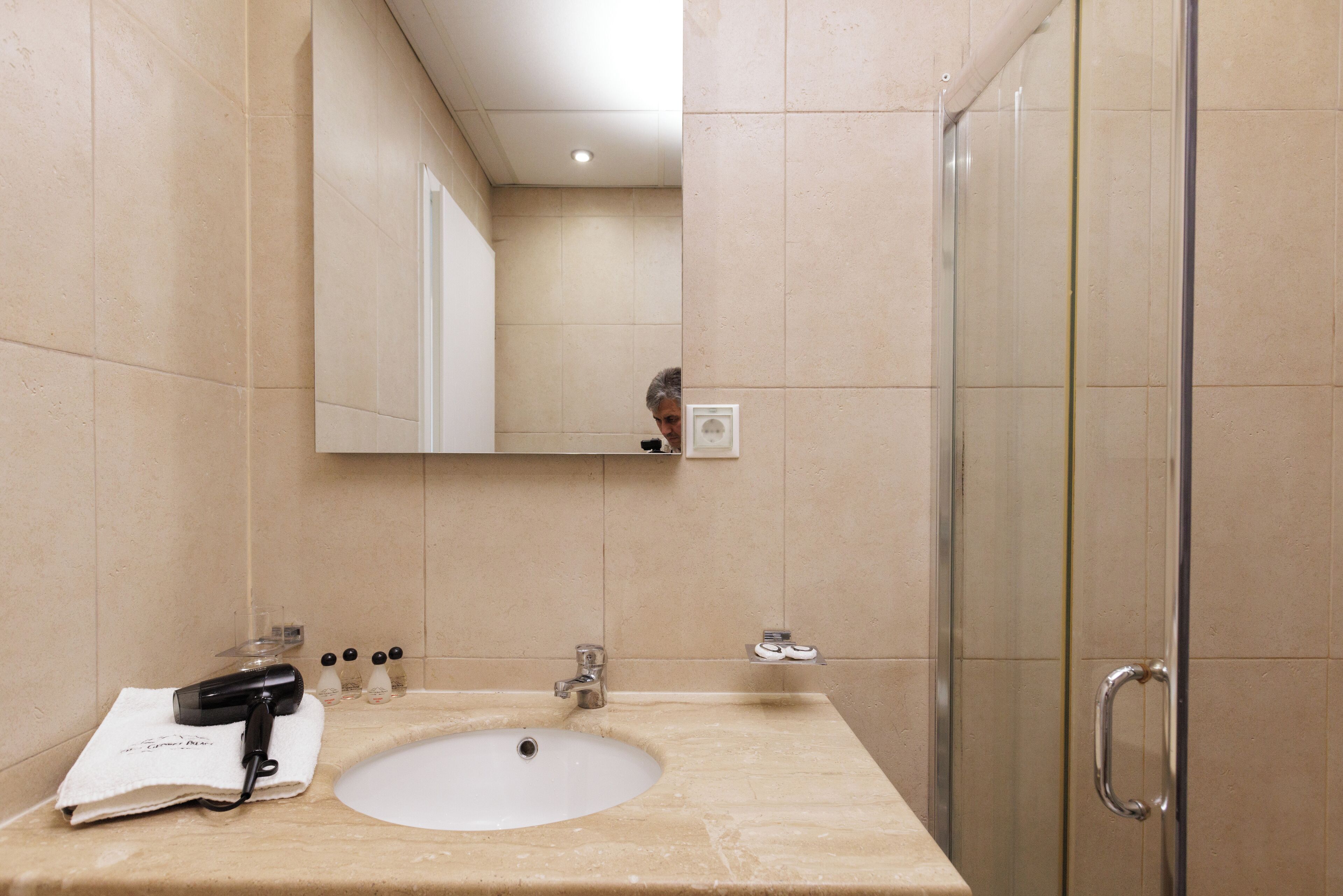 Un baño con lavamanos, espejo y ducha.
