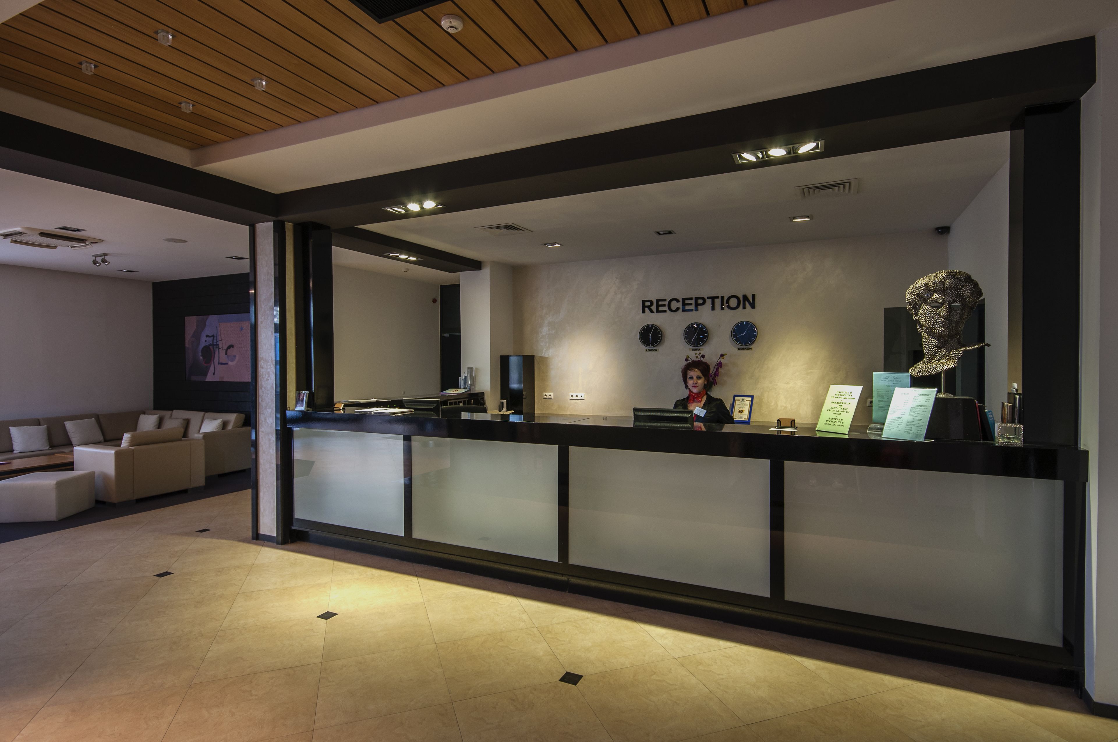 Een receptiegedeelte met een modern design, inclusief een receptiebalie, een wandklok en een receptietoolbalie.
