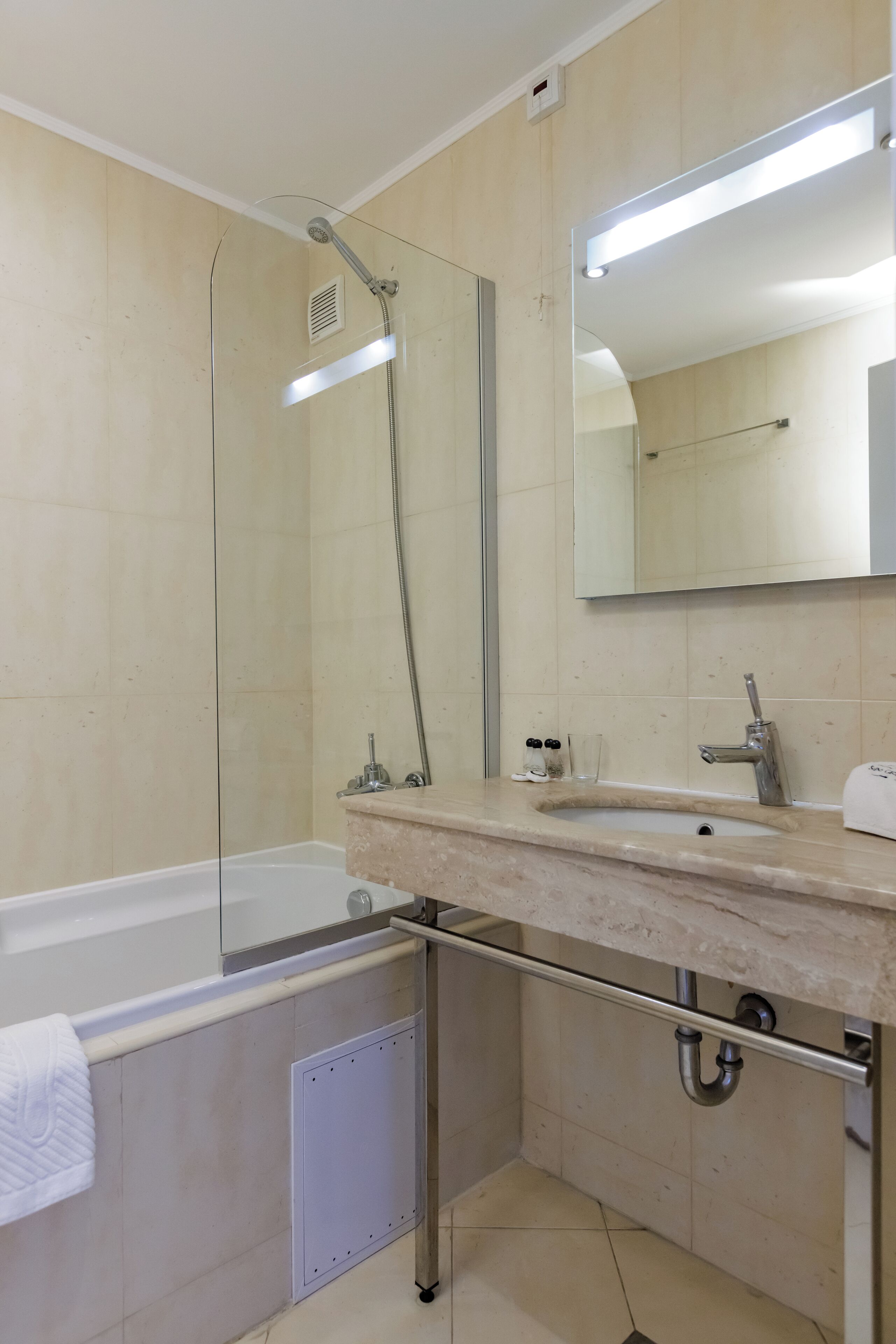 Un baño moderno con bañera, lavabo, espejo y ducha.
