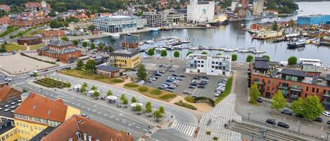 A coastal cityscape with a marina, modern buildings, and a historic church.