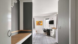 Una habitación de hotel moderna con una cama, un escritorio, una silla y un televisor.