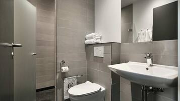 A modern bathroom with a toilet, sink, and towel rack.