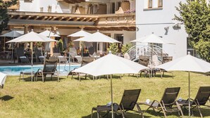 A large hotel with multiple balconies, outdoor seating, and a pool area. - Hotel Gaspingerhof (Gerlos)