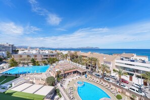 Un resort con una gran piscina, varias edificaciones y vistas al mar.