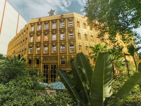 Un edificio con una fachada grande y ornamentada, que presenta un llamativo letrero de 'Dior' en la entrada.