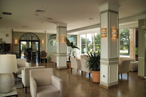 A spacious lobby with high ceilings, a reception desk, and seating areas. - Hotel Las Bovedas (Badajoz)
