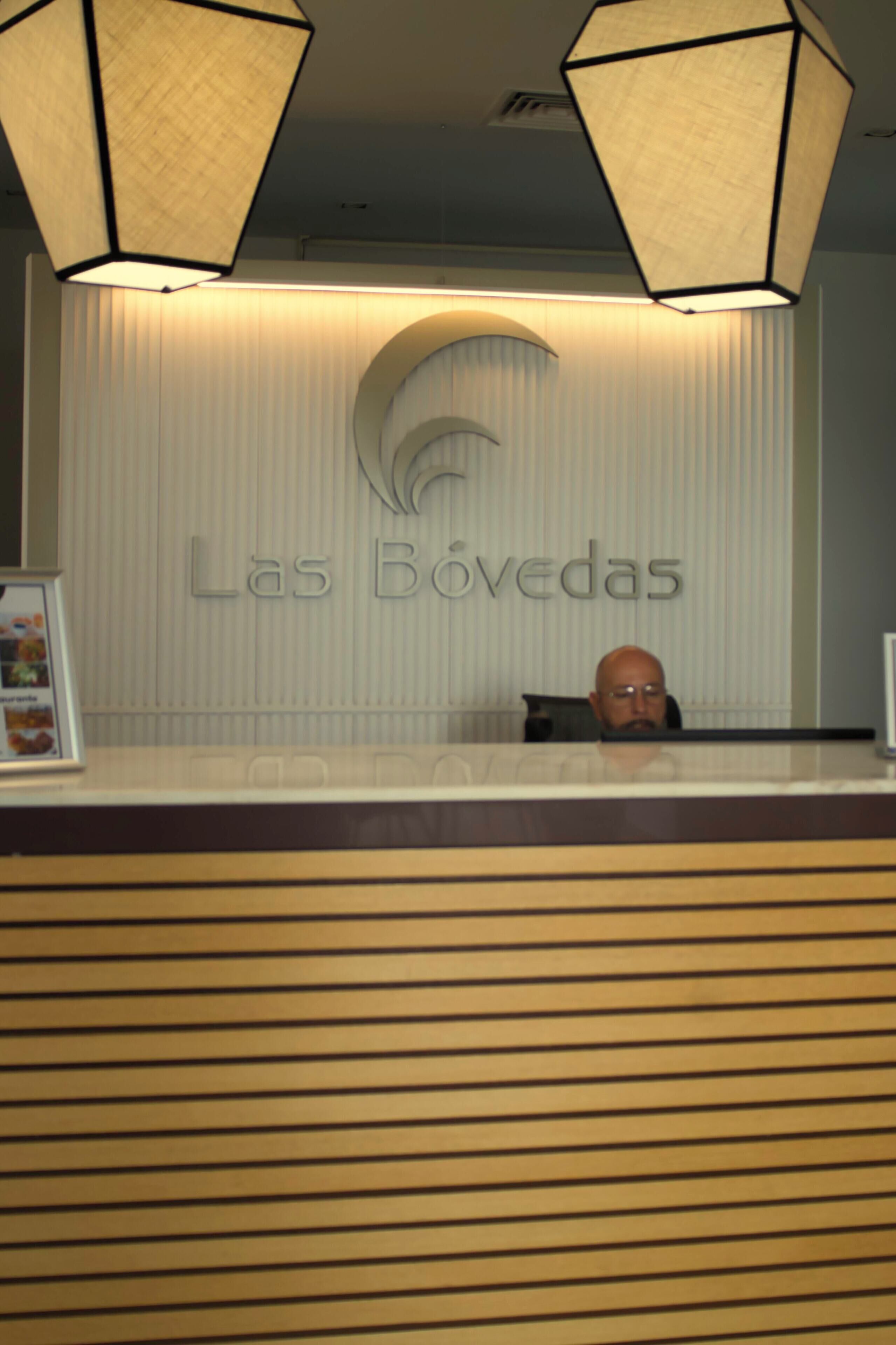 Uma mesa de recepção com uma placa que diz 'Las Bovedas'.