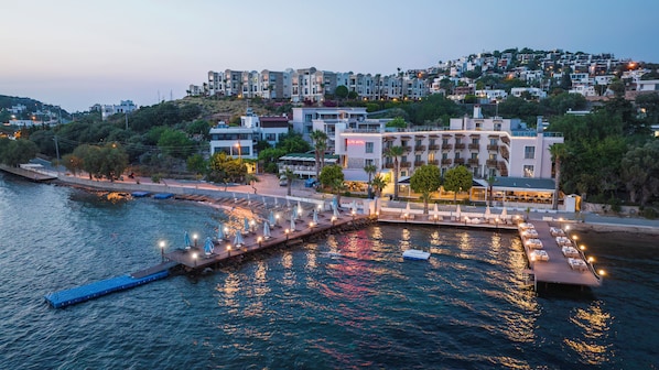 Hotel frente al agua con muelle, asientos al aire libre y vistas de la ciudad.