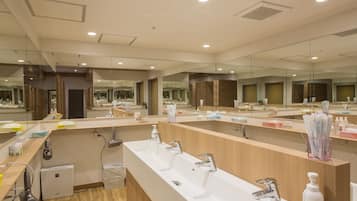 A modern bathroom with multiple sinks, mirrors, and a hairdryer.