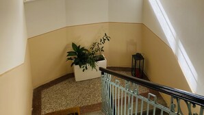 A staircase with a handrail, a potted plant, and three windows. - Apartment Barbara (Marianske Lazne)