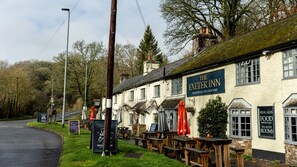 A traditional pub with outdoor seating, a signboard, and a stone wall. - The Exeter Inn (Tiverton)