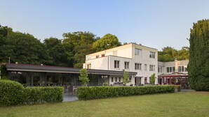 Un edificio moderno con techo plano, ventanas amplias y un césped bien cuidado.