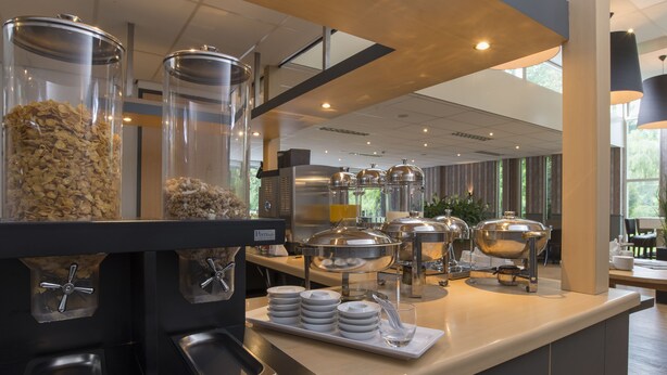 Una barra de buffet con diferentes recipientes de comida y fuentes.