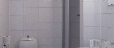 A bathroom with a toilet, sink, and shower.