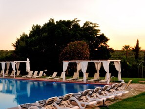 A poolside area with lounge chairs and a canopy structure.