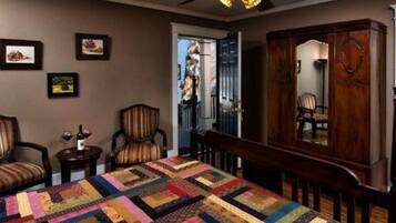 Una habitación con un edredón acolchado grande, muebles de madera y cuadros en la pared.