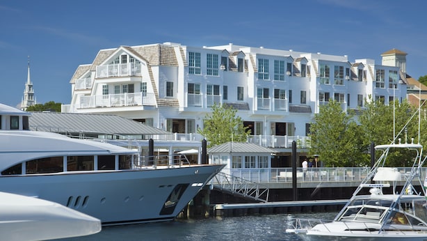 A waterfront property with a large white building featuring multiple balconies and a dock area with boats. - Forty 1 North (Newport)