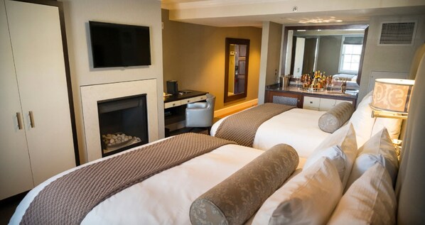 A hotel room with two beds, a TV, a desk, a mirror, and a minibar. - Forty 1 North (Newport)