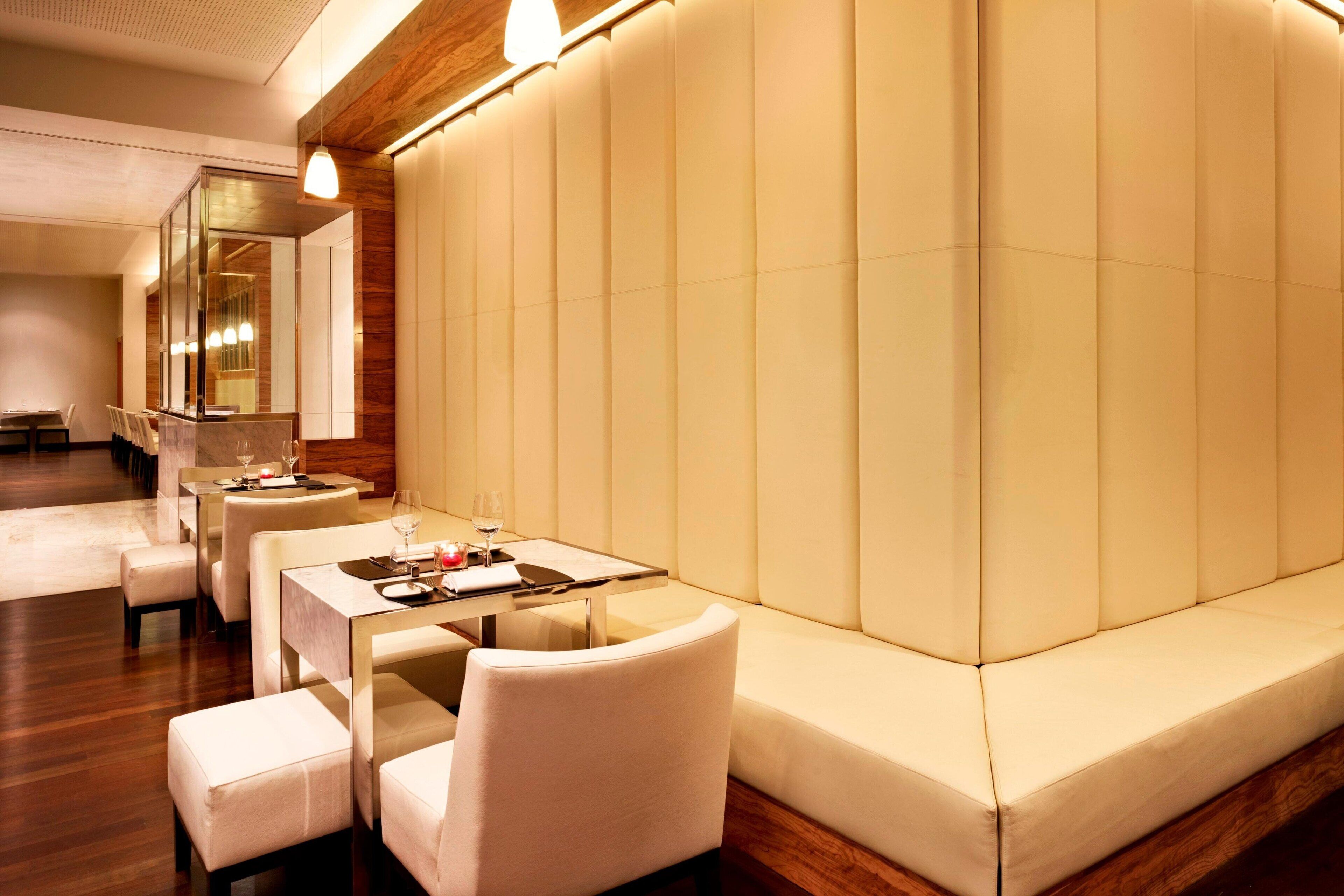 Un espace repas moderne comprenant un canapé, des tables et des chaises.
