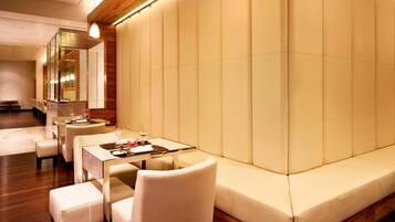 Un espace repas moderne comprenant un canapé, des tables et des chaises.