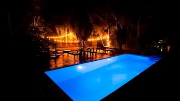 Relax by the pool surrounded by lush greenery and comfortable lounge seating.