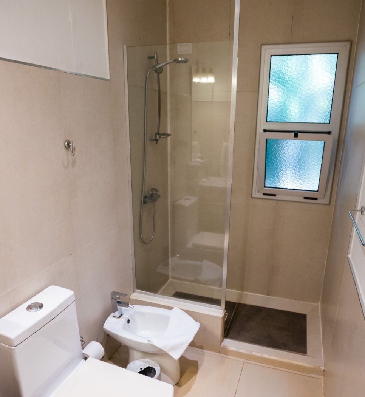 Ein Badezimmer mit Toilette, Bidet und einer Duschkabine.