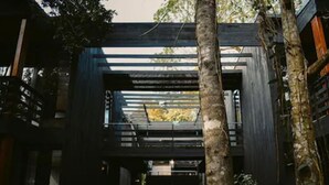 Un edificio moderno con fachada de vidrio y estructura metálica frontal.