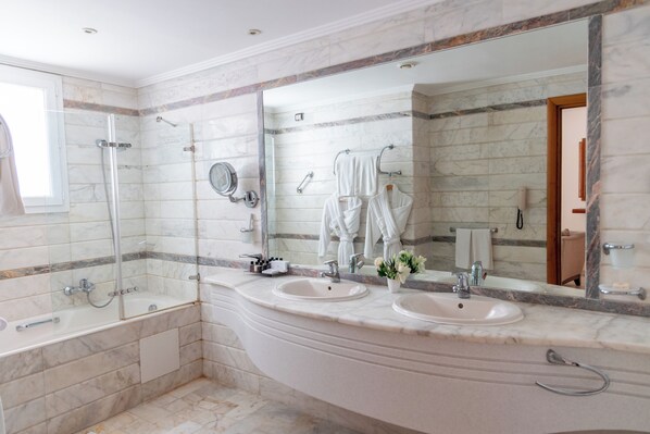A bathroom with two sinks, a bathtub, and a large mirror.