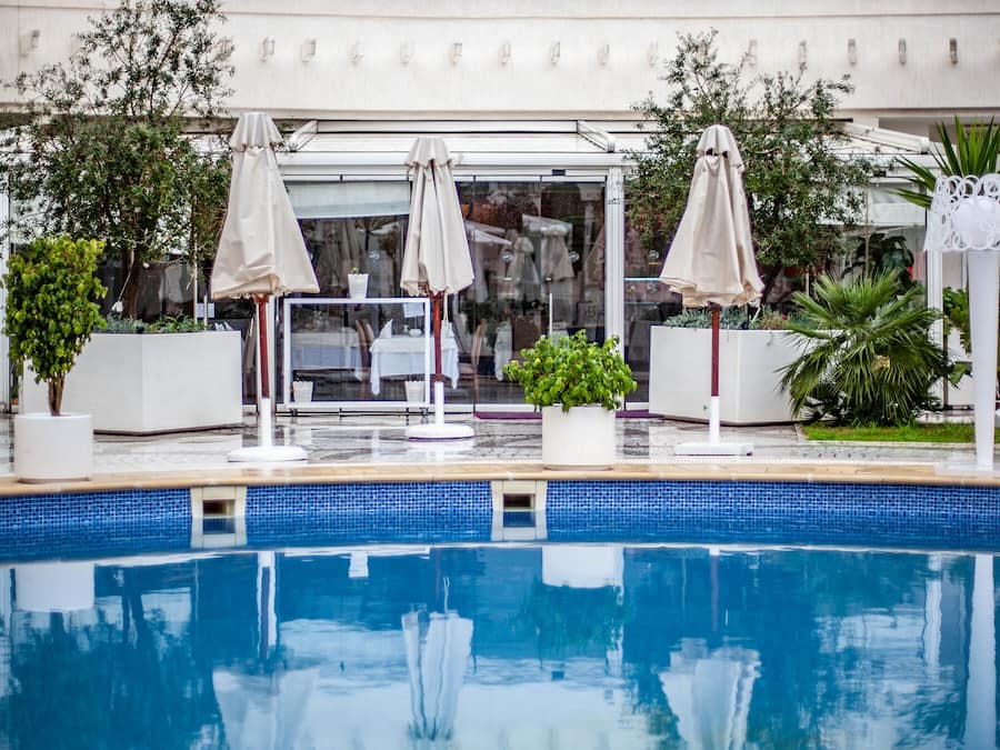 Alberca al aire libre, sombrillas en la alberca y camastros