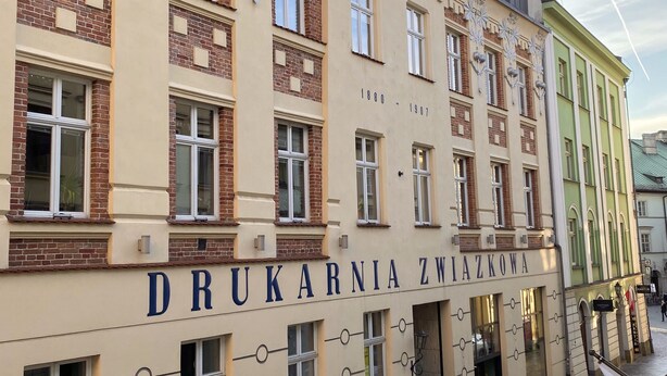 A historic building with the name 'DRUKARNIA ZWIĄKOWA' and a date range '1880-1907' indicating its period. - Hotel Wit Stwosz (Kraków)