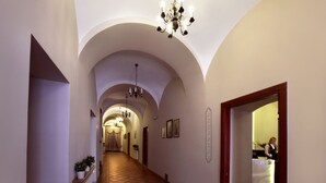 A hotel hallway with arched ceilings, a reception desk, and a chandelier. - Hotel Wit Stwosz (Kraków)
