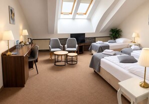 A hotel room with a desk, two armchairs, a TV, two beds, and a skylight. - Hotel Wit Stwosz (Kraków)