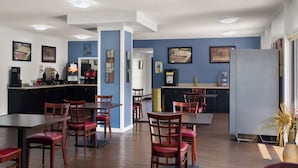 Un restaurante con zona de bar, mesas y sillas de madera.