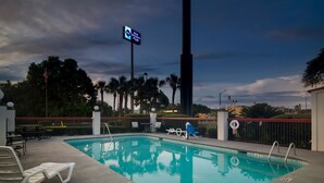 A swimming pool with lounge chairs and a sign for Best Western Plus.