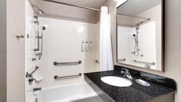 Une salle de bain moderne équipée d’une baignoire, d’un lavabo et d’une douche avec un pommeau de douche amovible.