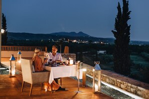 Un couple est assis à une table, devant un paysage montagneux.