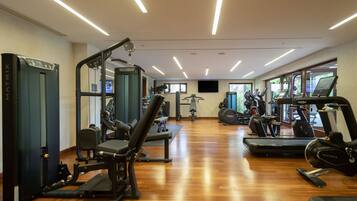 A gym with various exercise equipment, including treadmills, elliptical machines, and weight machines.