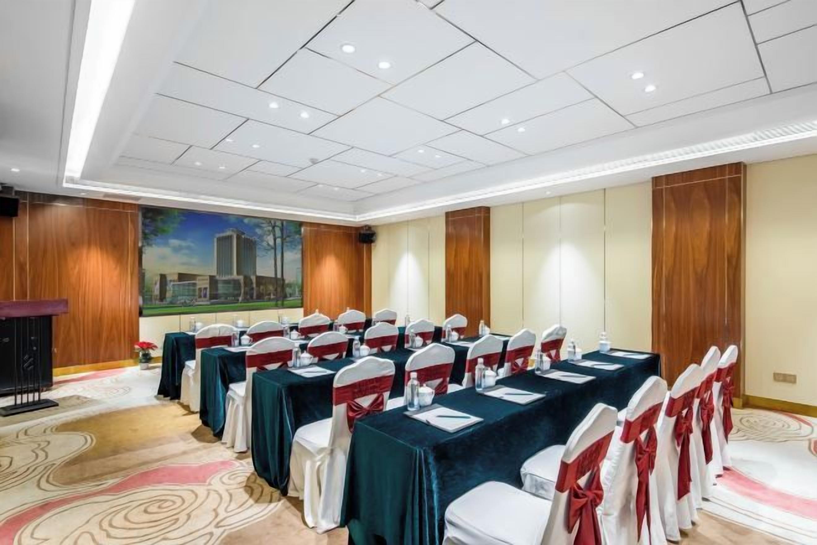 Una sala conferenze con un lungo tavolo, sedie e un podio.