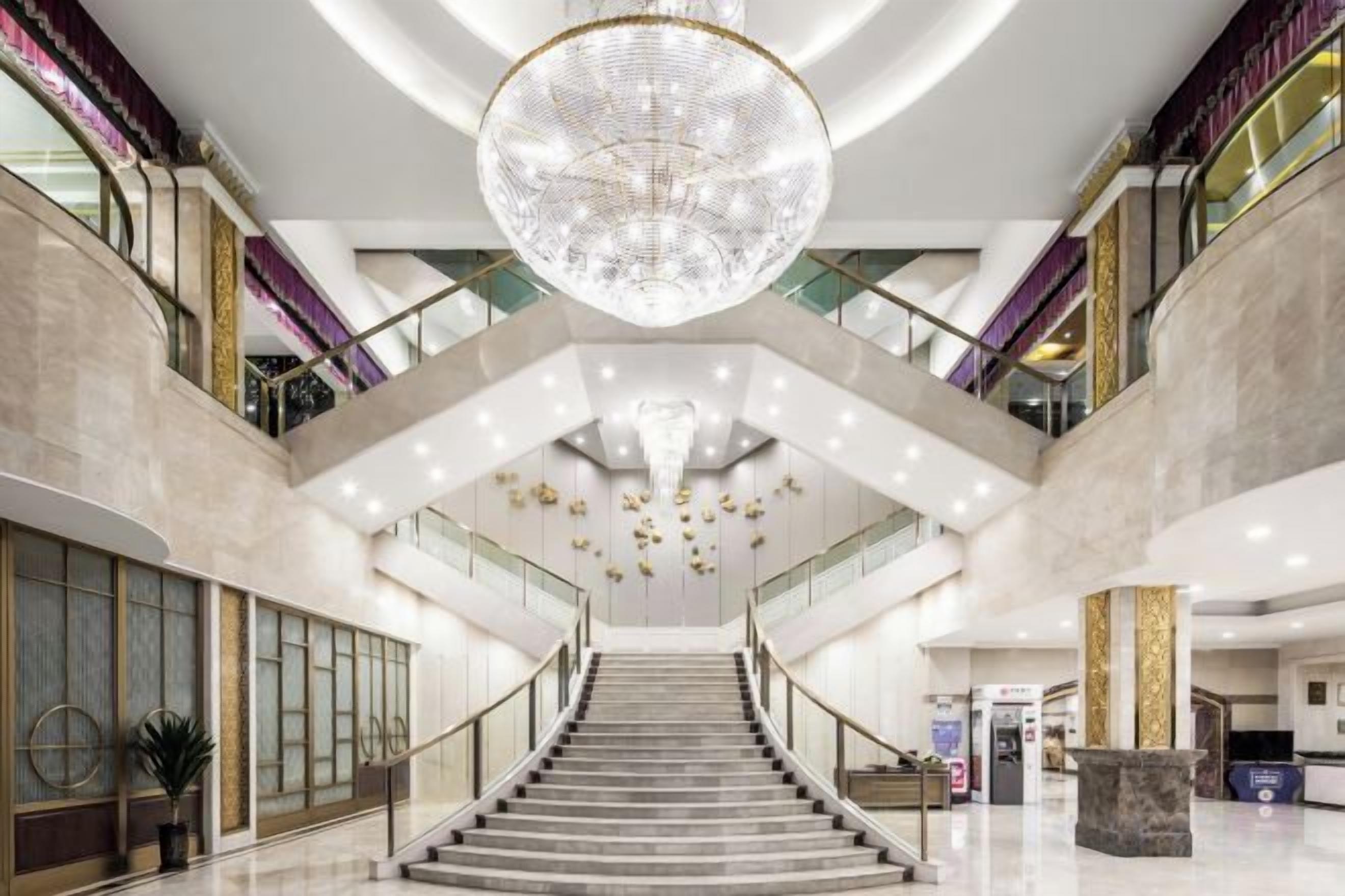 Ein großzügiger Innenraum mit einer prachtvollen Treppe, einem imposanten Chandelier und einem modernen Design.