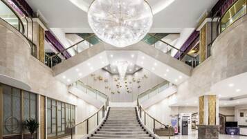 Ein großzügiger Innenraum mit einer prachtvollen Treppe, einem imposanten Chandelier und einem modernen Design.