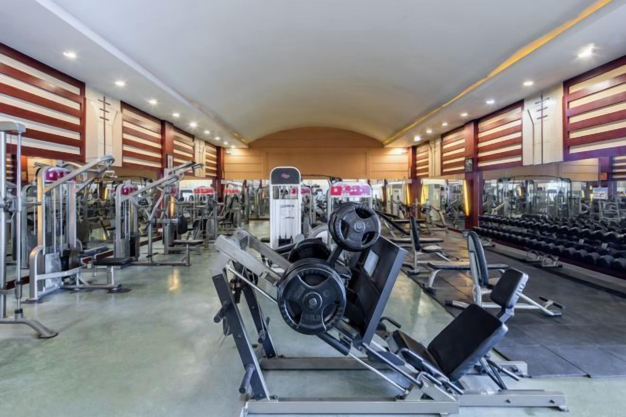 A gym with various exercise equipment, including weight machines and free weights.