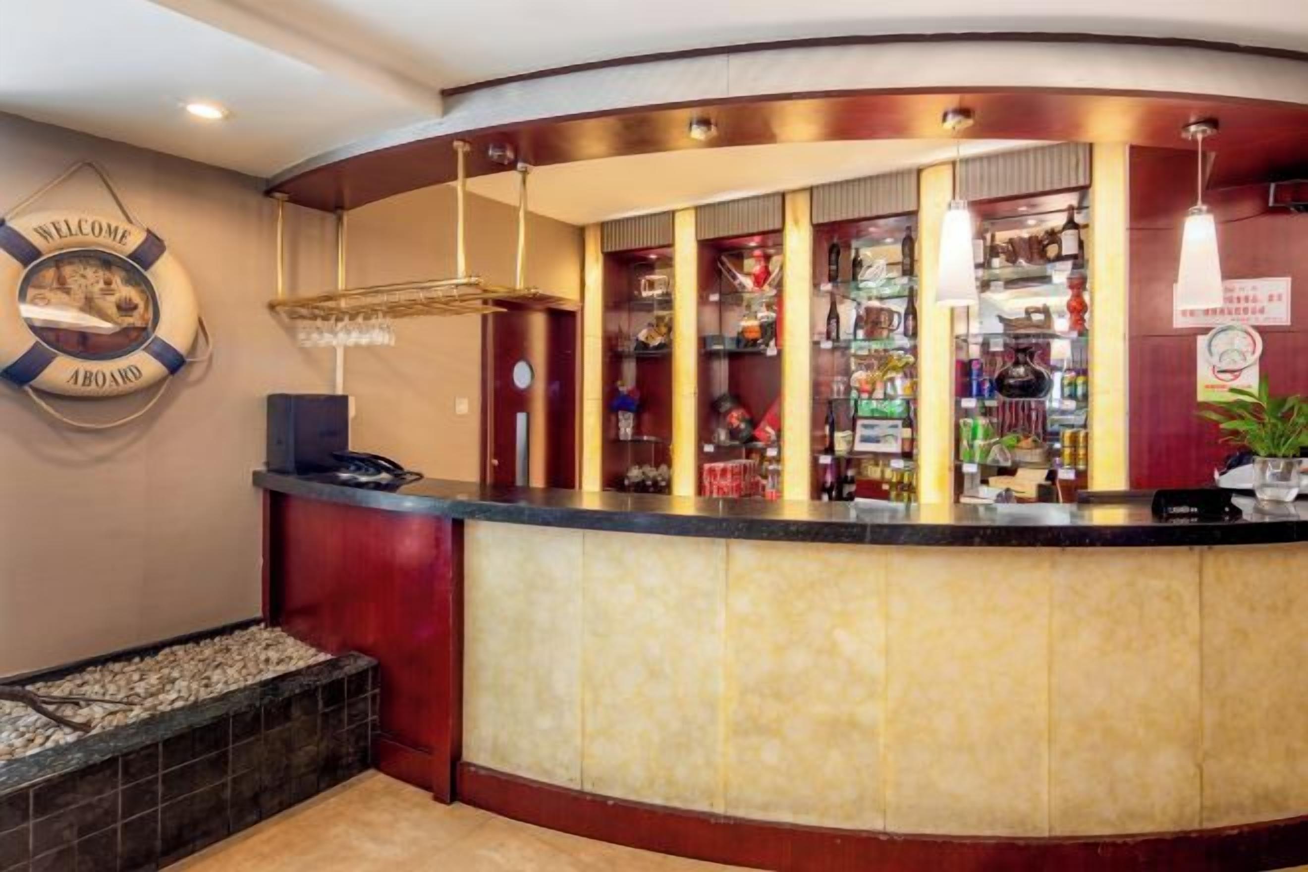 A reception area with a curved counter, a life preserver sign, and a variety of items on shelves behind the counter.