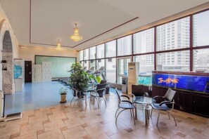 A spacious lobby with a large aquarium, seating area, and a view of the city. - Enraton International Hotel (Xining)