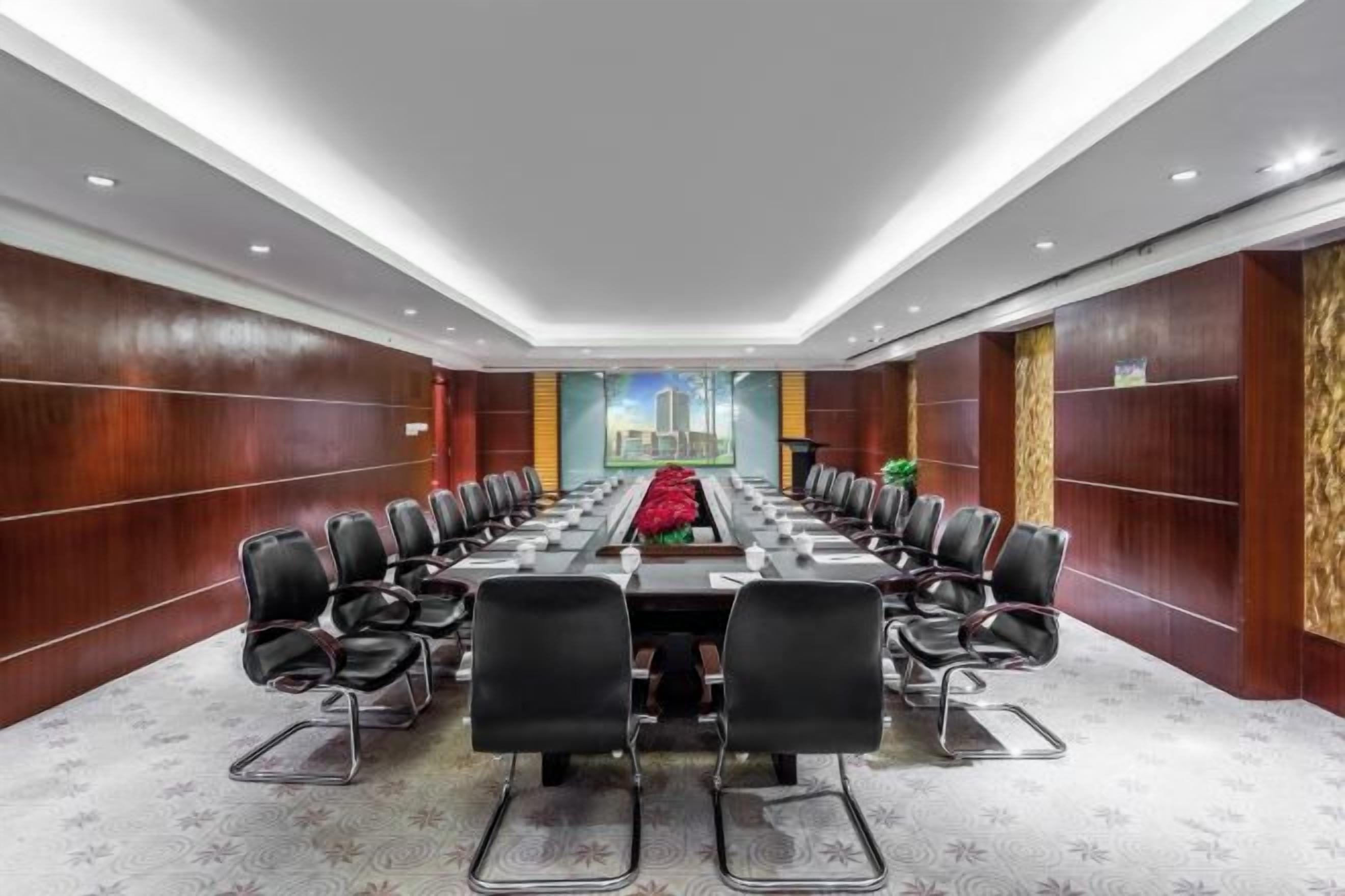 A conference room with a long table, chairs, and a cityscape view.