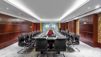 A conference room with a long table, chairs, and a cityscape view.